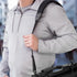 Person wearing a gray jacket carrying a bag over their shoulder, showcasing the EVORETRO shoulder strap against a blurred background.