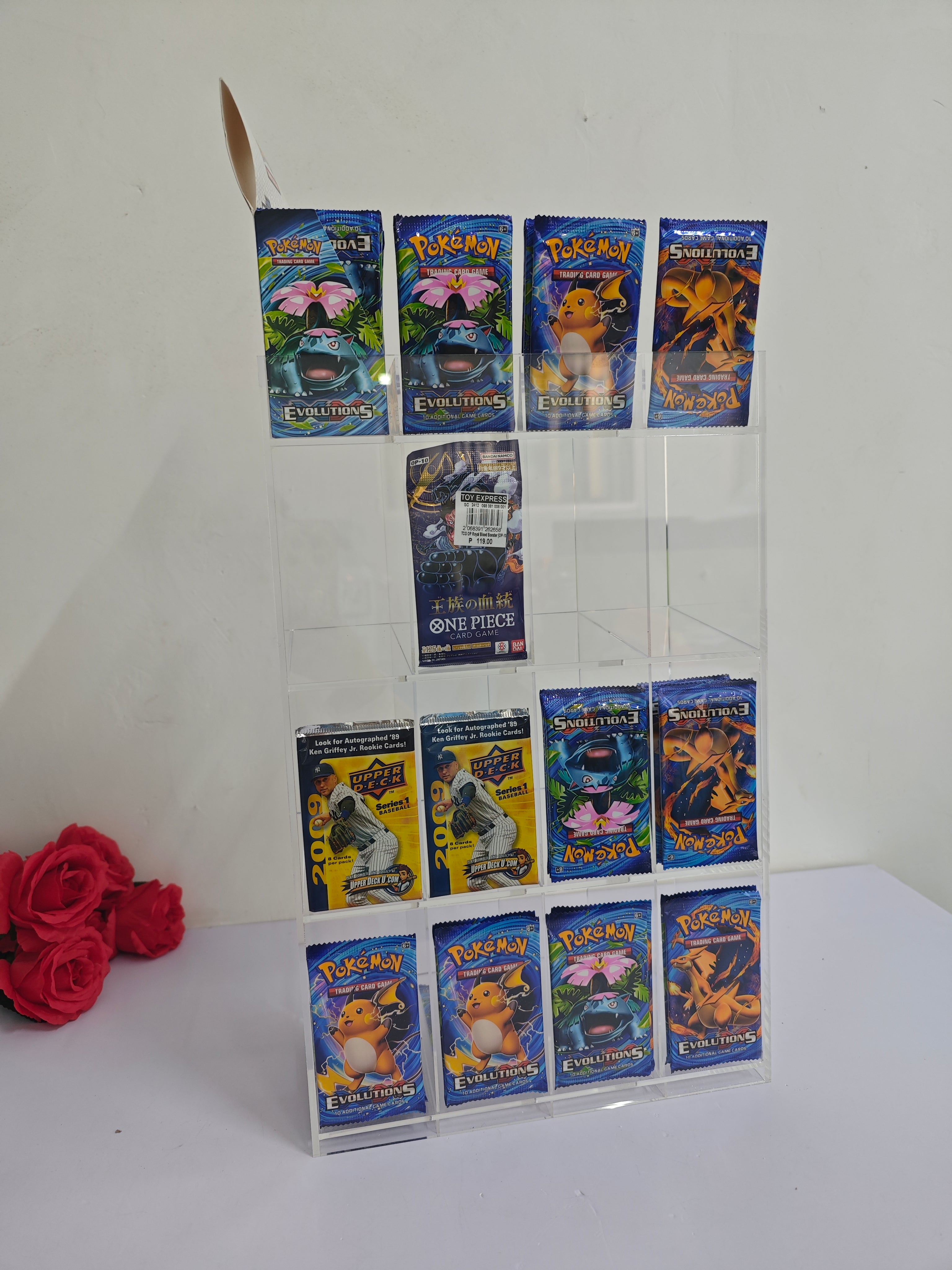 Collection of Pokémon trading cards displayed on a clear acrylic stand with a white background.