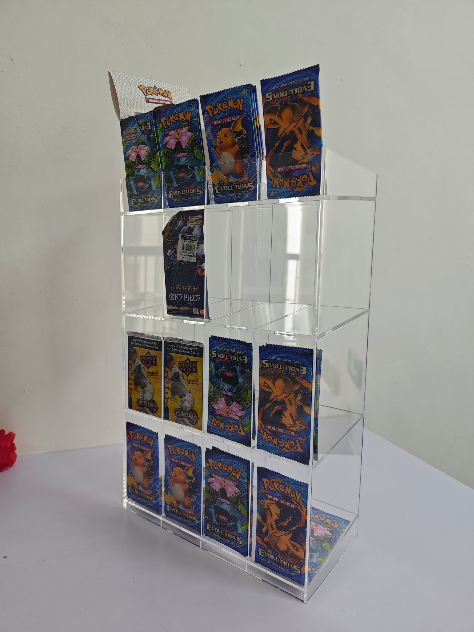 Acrylic display case with Pokemon trading cards on a white surface.