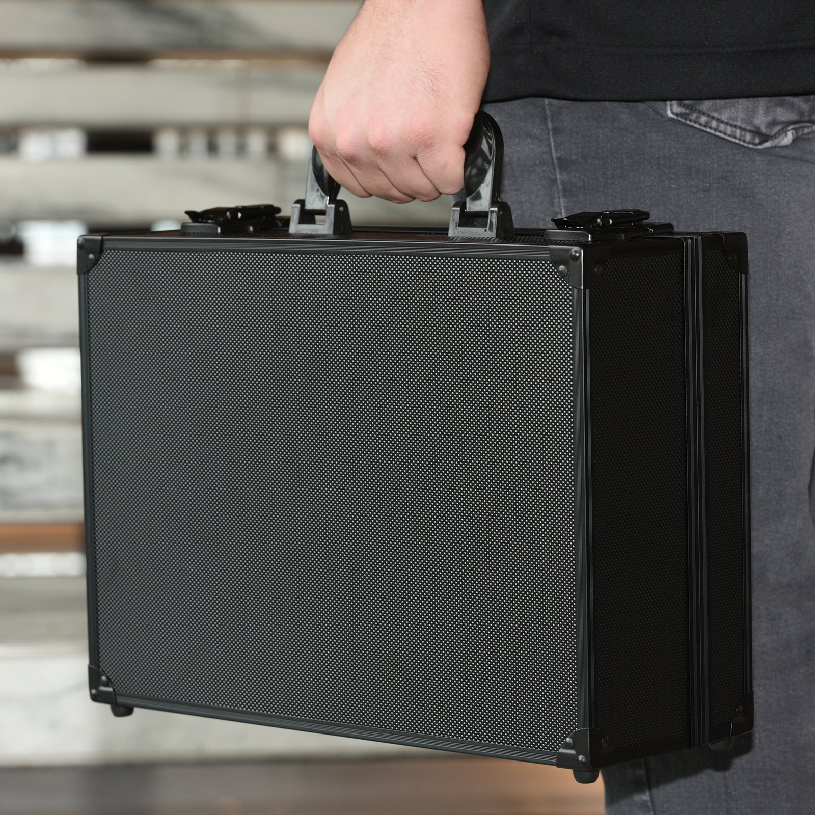 Man holding toploader card storage box by the handle, durable case design for magnetic and toploader cards