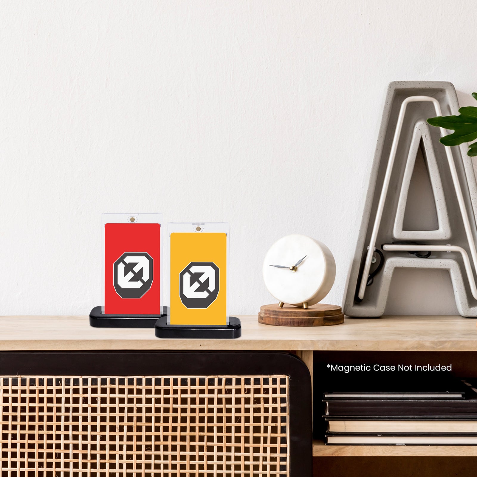Two black slab display stands with Evoretro logo, red and yellow, on wooden table with clock and letter A in background