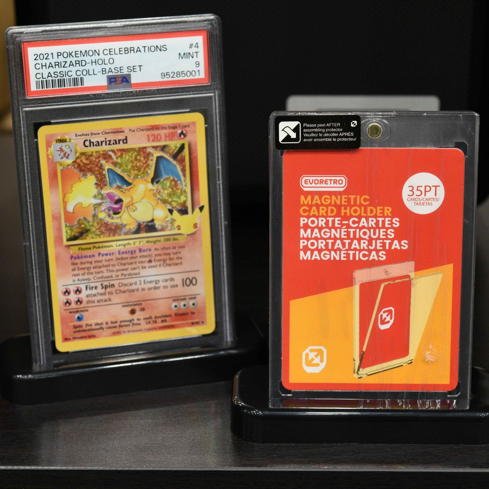 Two black display stands with PSA card and one touch card holder on black surface