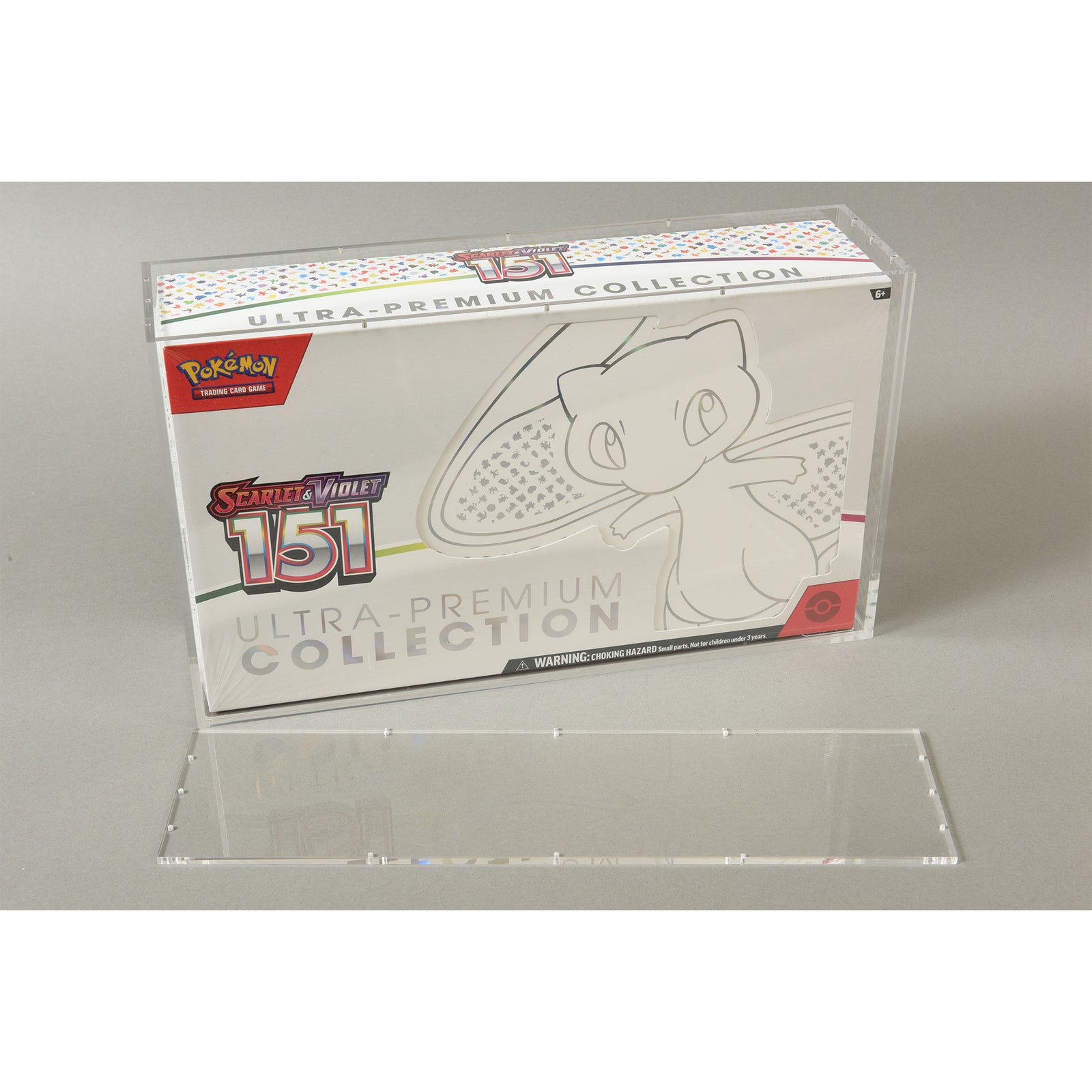 Pokemon 151 Ultra-Premium Box in acrylic case with lid off on gray background.