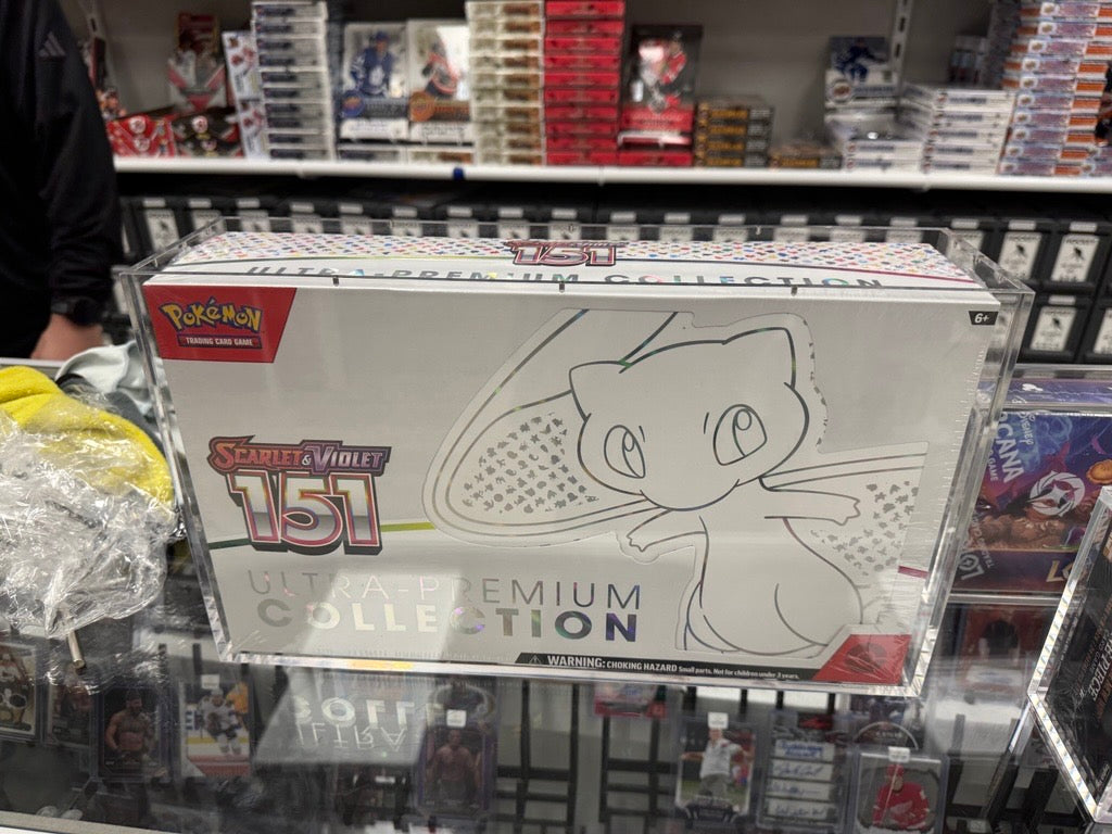 Pokémon Meowth-themed box inside acrylic case on a store display shelf.