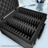 Empty black graded card case with foam lining and divider, placed on a light blue surface.
